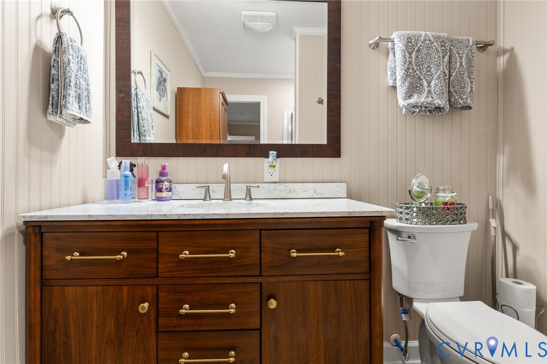8674 Mary Ball Road Lancaster, VA 22503 - Photo 26 of 38 a bathroom with a granite countertop toilet sink and mirror