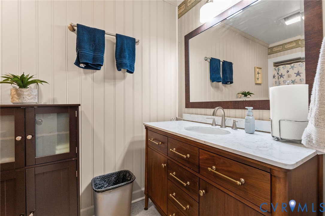 8674 Mary Ball Road Lancaster, VA 22503 - Photo 31 of 38 a bathroom with a granite countertop sink and a mirror