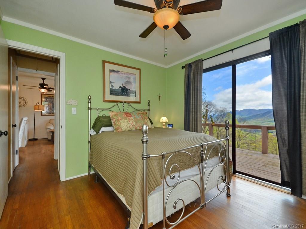 338 The High Road Waynesville, NC 28786 - Photo 12 of 19 a bedroom with a balcony a bed and a chandelier