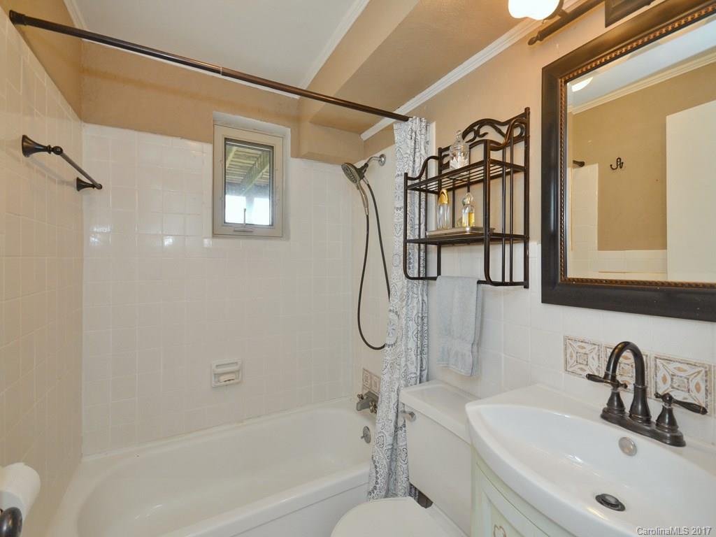 338 The High Road Waynesville, NC 28786 - Photo 16 of 19 a bathroom with a granite countertop sink a toilet and a bathtub