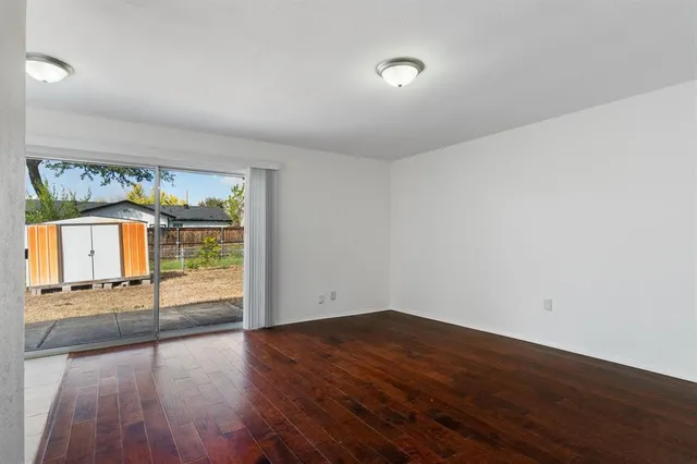 a view of a room with wooden floor and a window