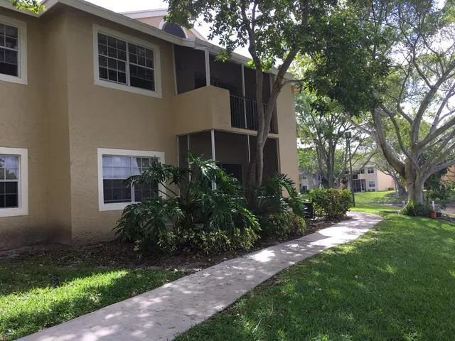 a view of a house with a yard and tree s