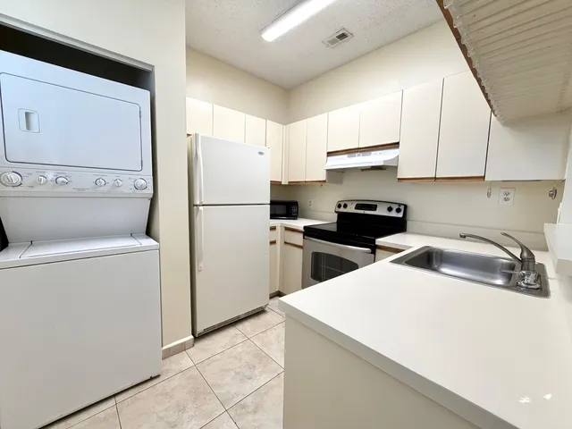 a kitchen with a refrigerator a sink and cabinets