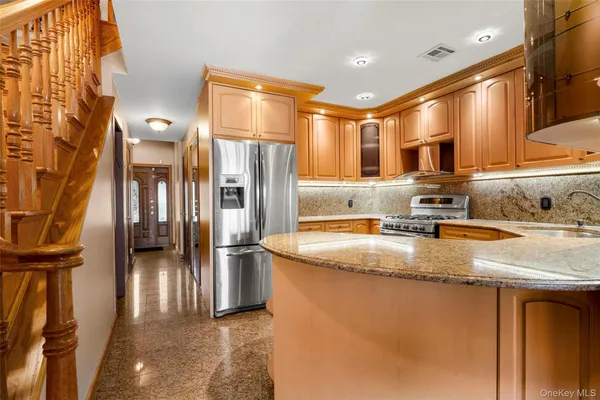 a kitchen with stainless steel appliances granite countertop a refrigerator a sink and a stove