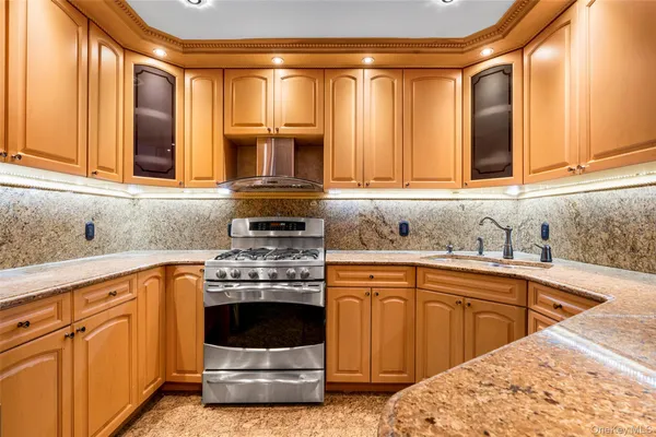 a kitchen with stainless steel appliances granite countertop a sink stove and cabinets