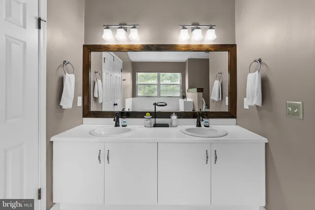 a bathroom with a bathtub sink and mirror