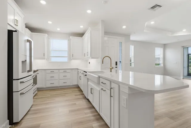 a view of a kitchen with kitchen island a sink stainless steel appliances and cabinets