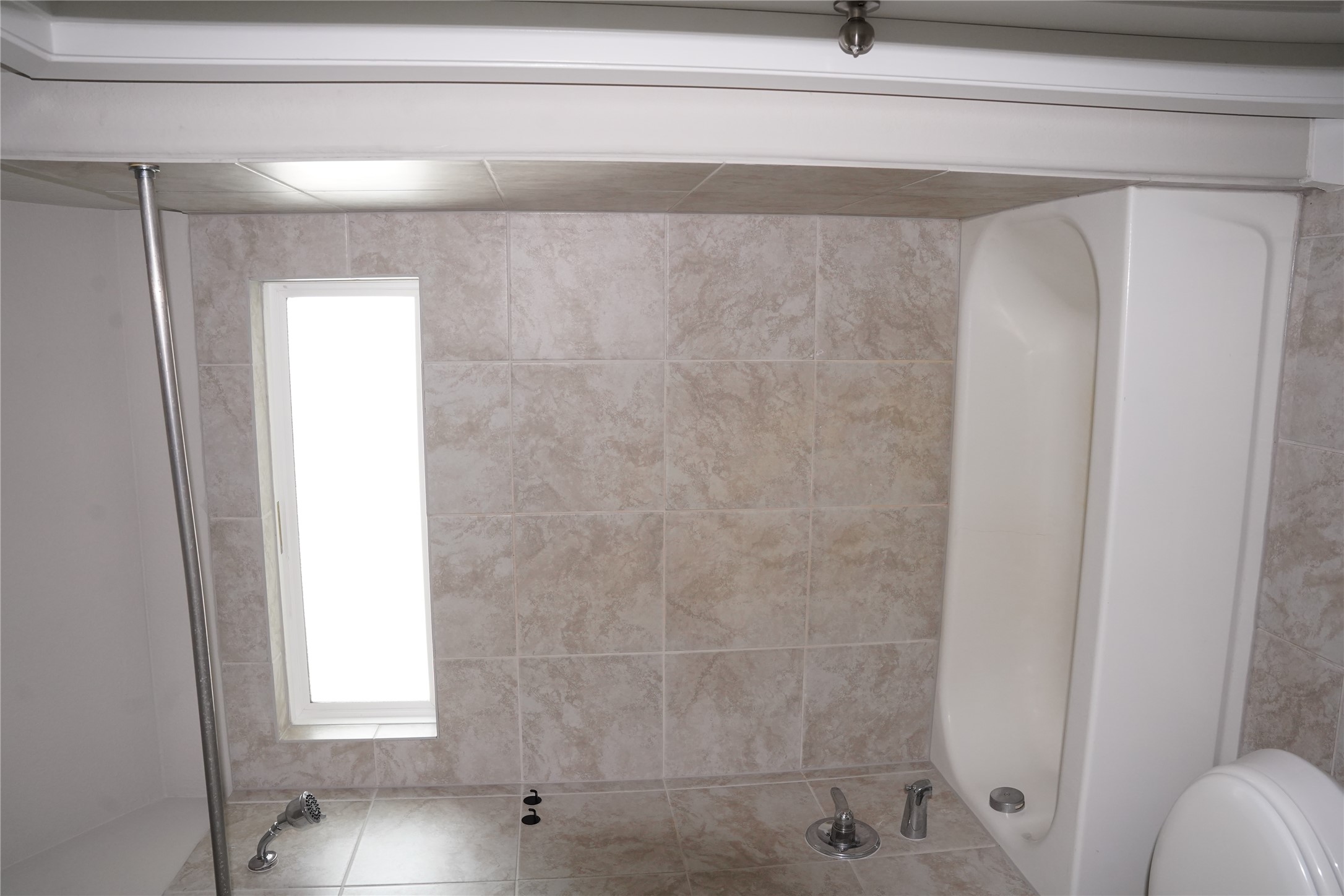 117 Crescent Street Georgetown, TX 78626 - Photo 35 of 38 A well-lit primary bathroom with a clean bathtub and shower features a practical, tiled enclosure.