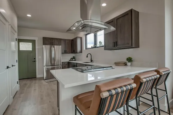 a kitchen with a table chairs refrigerator and cabinets
