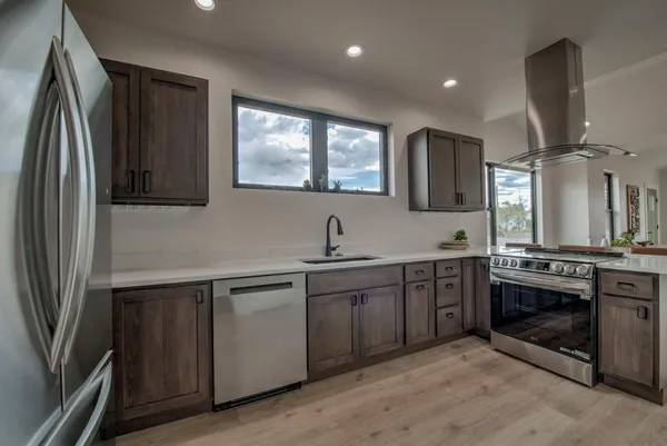 a kitchen with stainless steel appliances granite countertop a sink stove and refrigerator