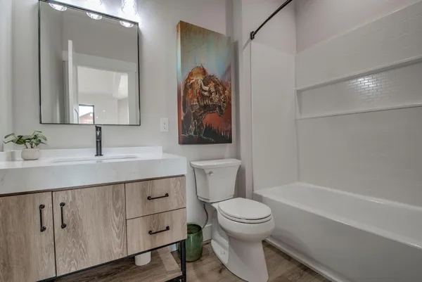 a bathroom with a sink a toilet and shower