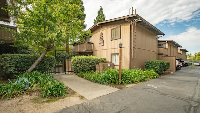 a white house with a small yard plants