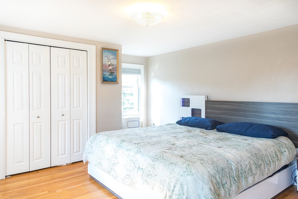 6 Ralph Road Marblehead, MA 01945 - Photo 10 of 29 a bedroom with a large bed and a chandelier