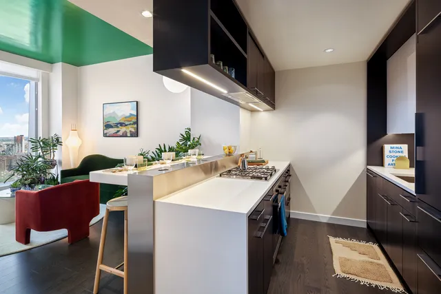 a kitchen with stainless steel appliances kitchen island a table and chairs in it
