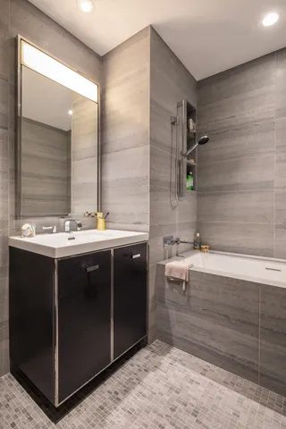 a bedroom with a bed a mirror and a large window