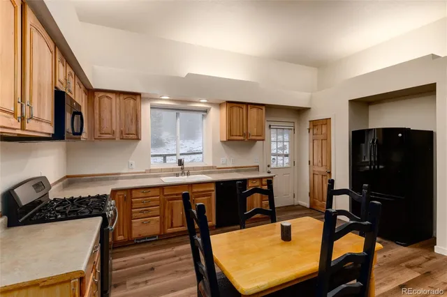 a kitchen with a table chairs refrigerator and cabinets