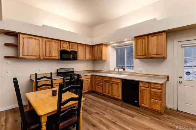 a kitchen with stainless steel appliances granite countertop wooden cabinets a stove top oven a sink and dishwasher