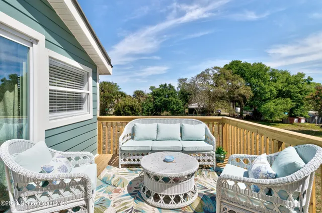 a view of backyard with deck and outdoor seating