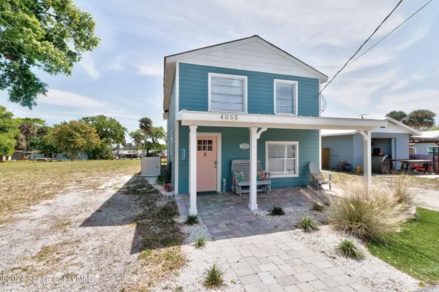 a view of a house with a patio and a yard