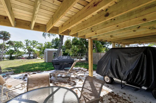 a view of a patio with a table chairs and a fire pit