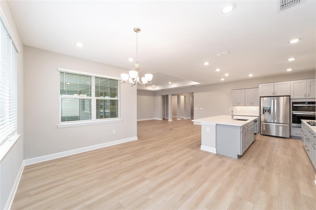 10305 Southwest 105th Street Ocala, FL 34481 - Photo 17 of 44 a view of a kitchen with kitchen island a counter top space appliances and a ceiling fan