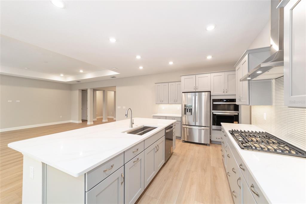 10305 Southwest 105th Street Ocala, FL 34481 - Photo 18 of 44 a kitchen with stainless steel appliances granite countertop a sink stove and refrigerator