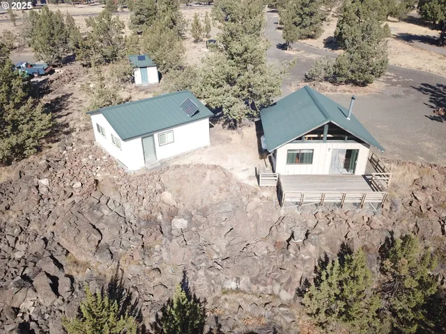 a view of a house with a yard and wooden fence