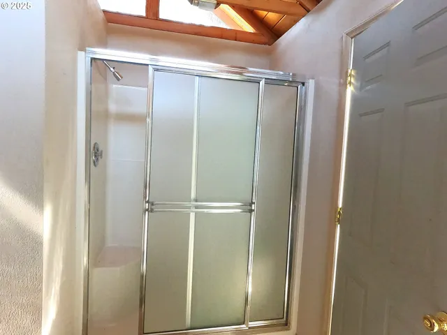 a bathroom with a glass shower door and sink
