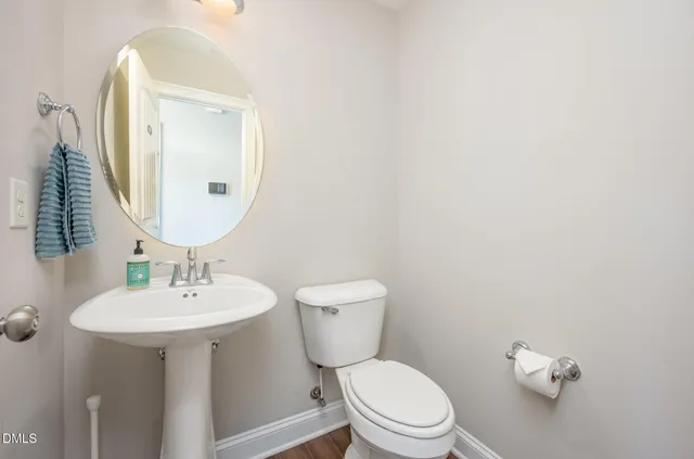 a bathroom with a toilet a sink and mirror