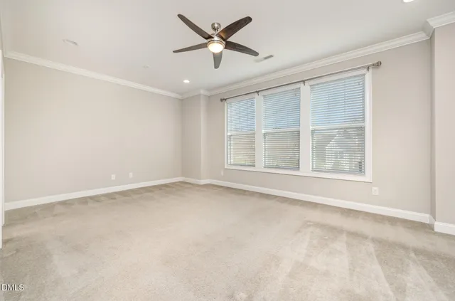 an empty room with a window and a ceiling fan