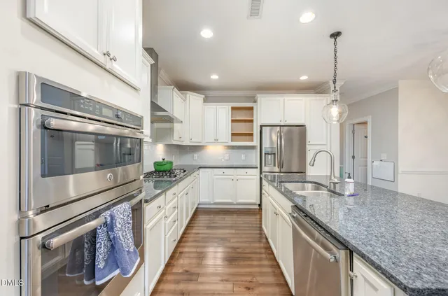 a large kitchen with stainless steel appliances granite countertop a sink and stove
