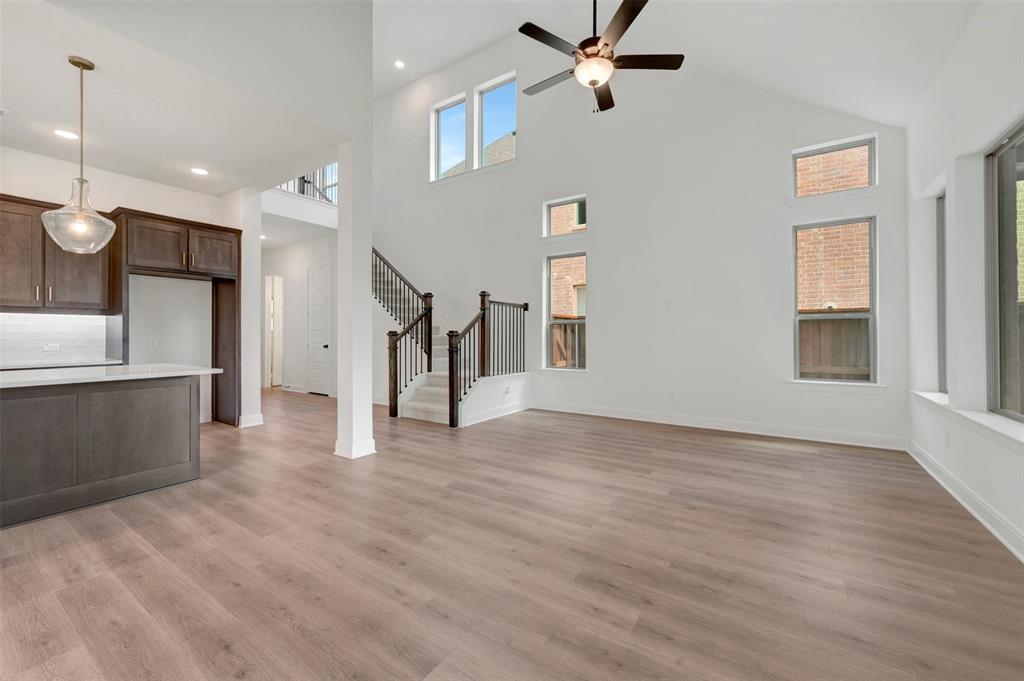 1908 Cola Drive Van Alstyne, TX 75495 - Photo 22 of 29 Spacious living area featuring a high vaulted ceiling with a ceiling fan, ample natural light from multiple windows, and wood-finish flooring