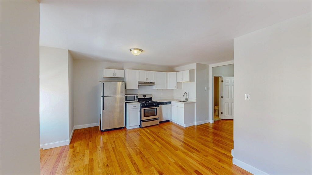 67 Marion Street, Unit 3 Boston, MA 02128 - Photo 3 of 16 a kitchen with a refrigerator and a stove top oven