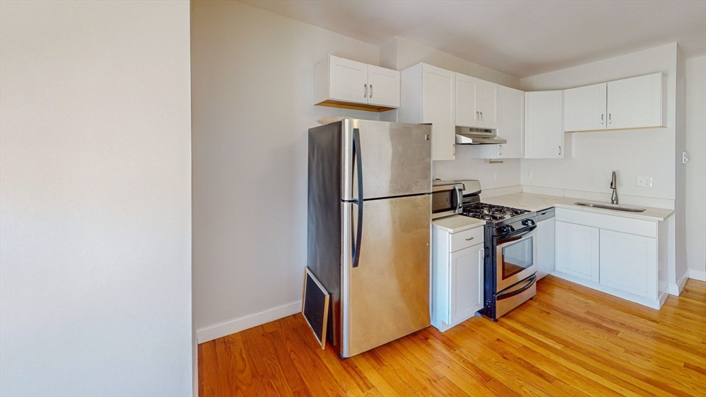 67 Marion Street, Unit 3 Boston, MA 02128 - Photo 4 of 16 a kitchen with a refrigerator sink and stove
