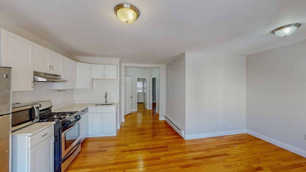 67 Marion Street, Unit 3 Boston, MA 02128 - Photo 5 of 16 a view of a kitchen with wooden floor