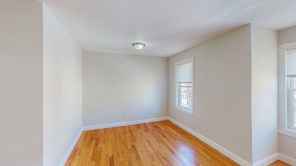 67 Marion Street, Unit 3 Boston, MA 02128 - Photo 6 of 16 a view of empty room with window and wooden floor