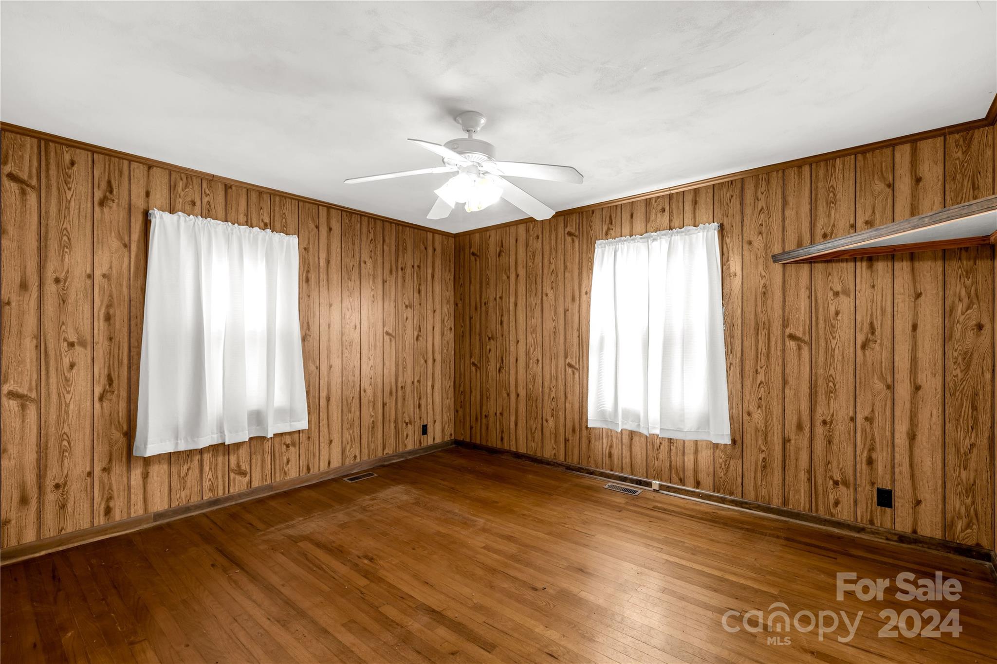 813 Potter Road Lancaster, SC 29720 - Photo 17 of 39 an empty room with wooden floor ceiling fan and windows