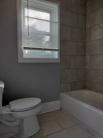 a white toilet sitting next to a bath tub