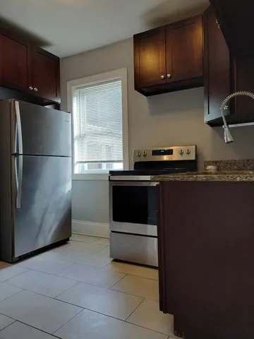 a kitchen with a refrigerator and a stove top oven