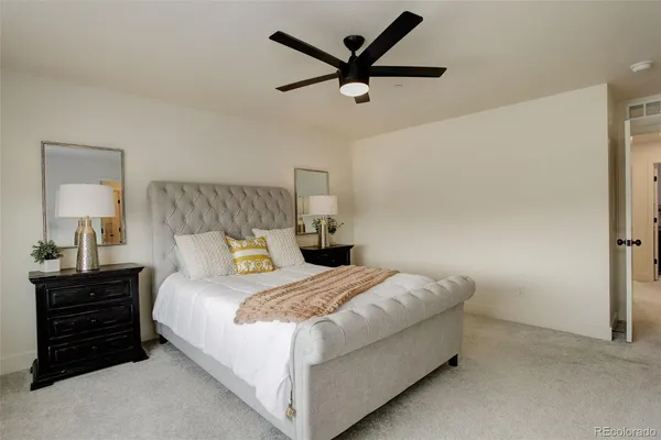 a bedroom with a bed a dresser and a chandelier