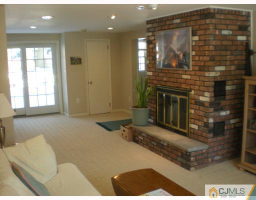 33 Clive Hills Road Edison, NJ 08820 - Photo 7 of 10 a living room with furniture a fireplace and a flat screen tv