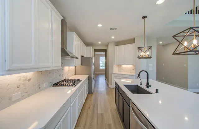 a kitchen with granite countertop a refrigerator and a stove