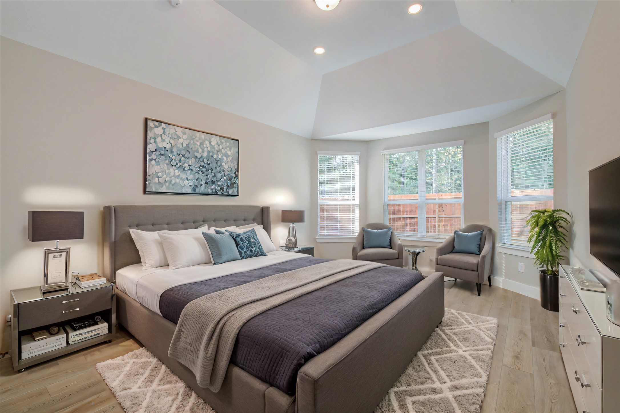 9950 Wild Indigo Circle Conroe, TX 77385 - Photo 21 of 50 a spacious bedroom with a bed a couch and potted plant on the dresser