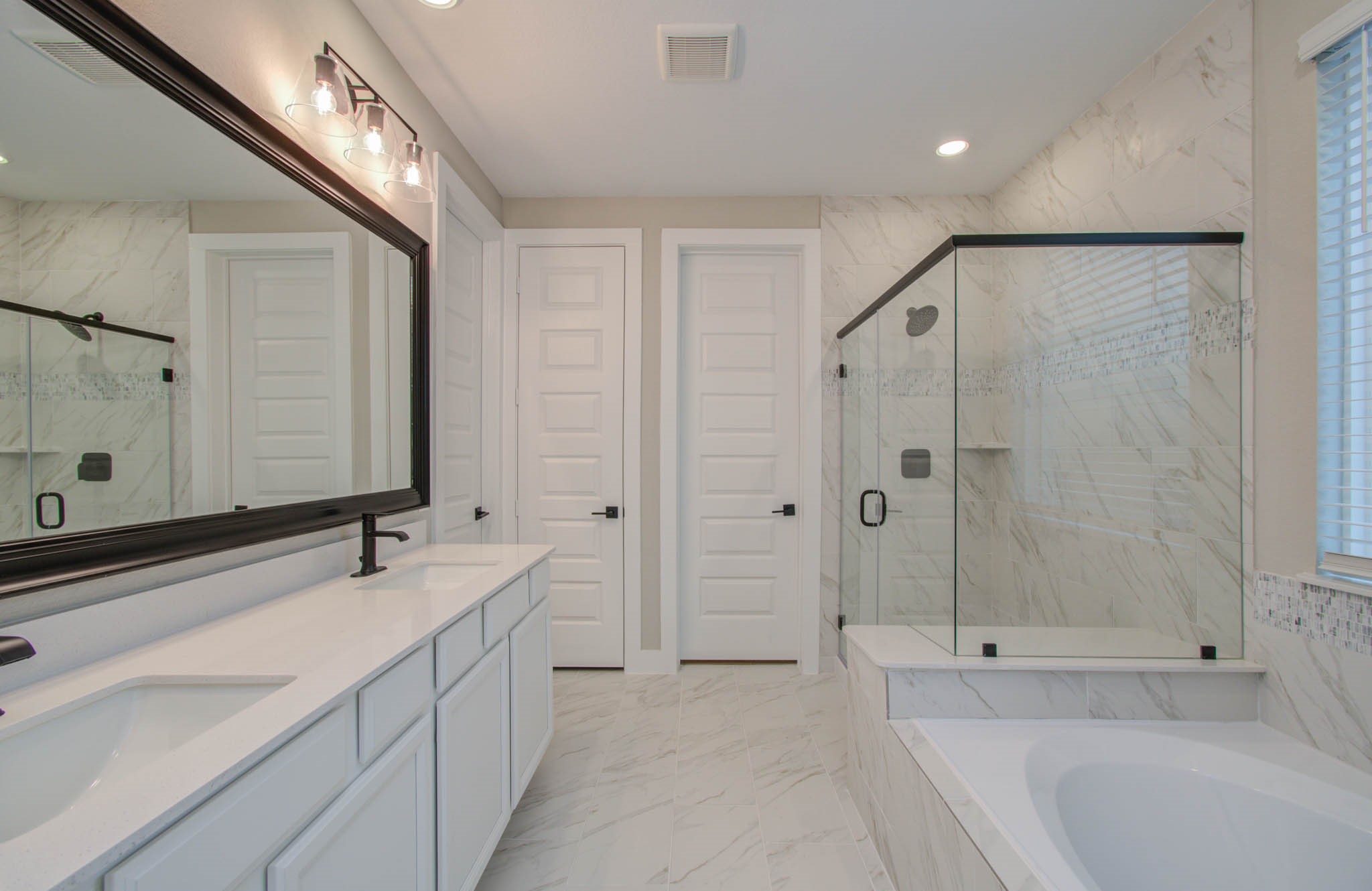 9950 Wild Indigo Circle Conroe, TX 77385 - Photo 23 of 50 a bathroom with a double vanity sink mirror double and bathtub