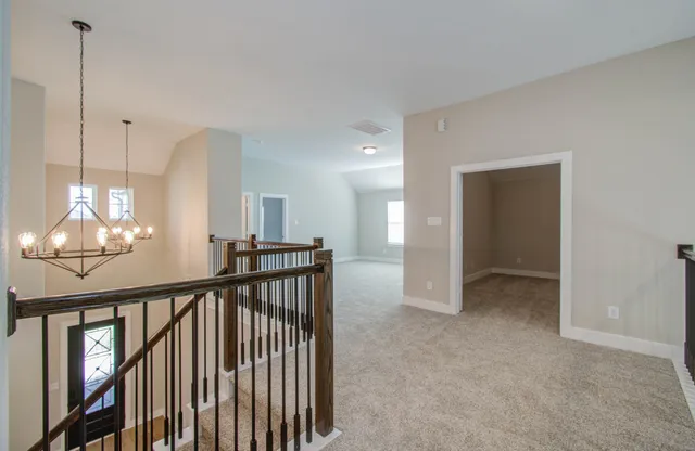 a view of an empty room with glass door and windows