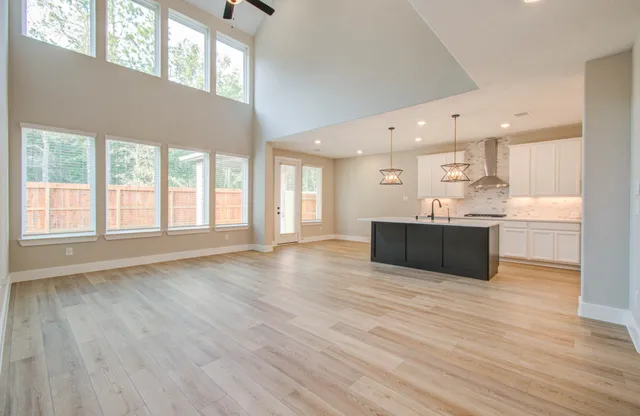 a view of a hallway with wooden floor and kitchen