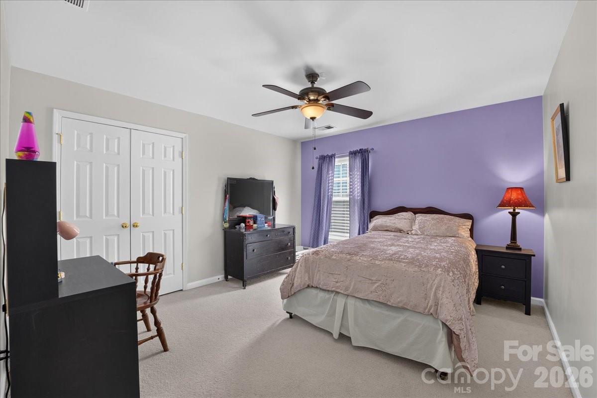 8006 Fine Robe Drive Indian Trail, NC 28079 - Photo 19 of 36 a bedroom with a bed and a chandelier