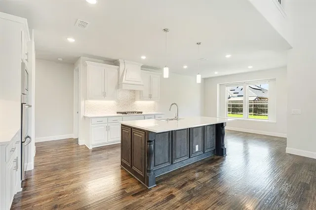 a view of kitchen with granite countertop a sink and wooden floor