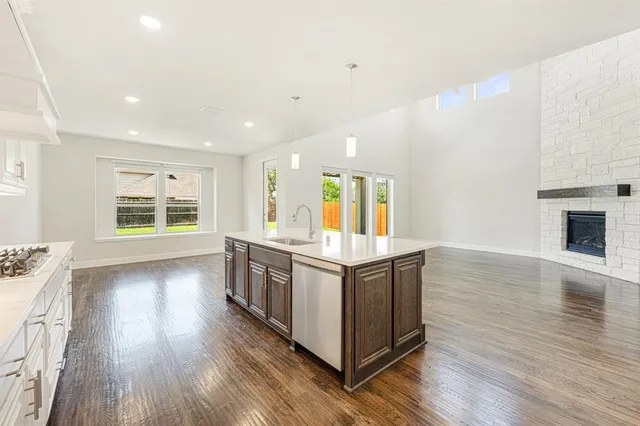 a kitchen with stainless steel appliances granite countertop a stove and a large window