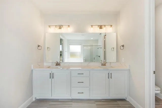 a bathroom with a double vanity sink and a mirror